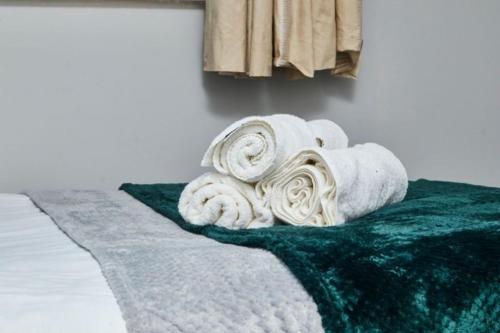a pile of towels sitting on top of a green rug at Oxford's Most Stylish House - Garden & Parking in Oxford