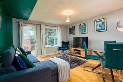 a living room with a blue couch and chairs at Oxford's Most Stylish House - Garden & Parking in Oxford