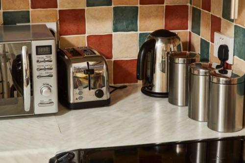 a counter top with a toaster oven and other appliances at Oxford's Most Stylish House - Garden & Parking in Oxford