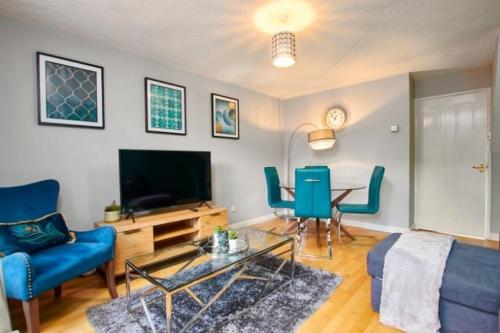 a living room with a blue couch and a tv at Oxford's Most Stylish House - Garden & Parking in Oxford