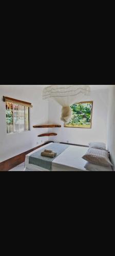 a bedroom with a bed and two windows at BOIPEBA Cantinho do Mirko 3 in Ilha de Boipeba