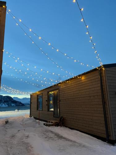 Alpan Apartments, Lyngenfjord في Olderdalen: مبنى صغير عليه انوار في الثلج