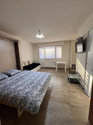 une chambre avec un lit et un canapé dans l'établissement STUDIO 50m de gare de st-louis, à Saint-Louis