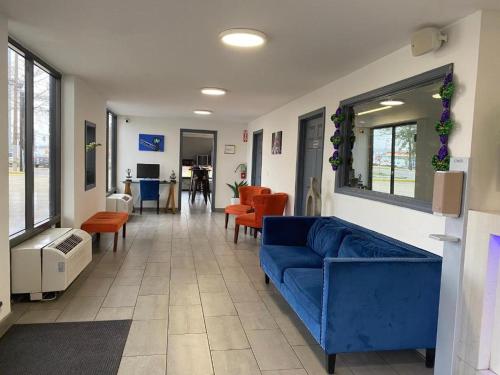 uma sala de estar com um sofá azul e cadeiras em Hotel 10 Extended Stay em Nova Orleães