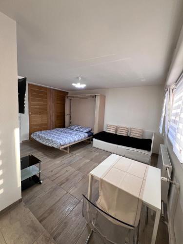 une petite pièce avec un lit et une table dans l'établissement STUDIO 50m de gare de st-louis, à Saint-Louis
