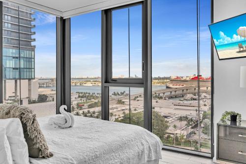 a bedroom with large windows with a view of a city at Waterline Corner Vies 2Br 2BA Suites in Miami