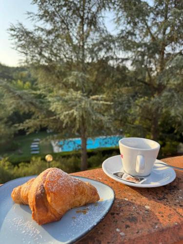 un plato con un cruasán y una taza de café en Cascina De' Fagiolari, en Lastra a Signa