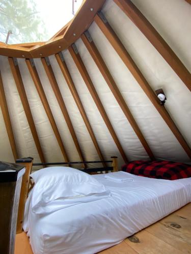 a bed in a room in a tent at Yourte Forêt des Murmures in Sacré-Coeur-Saguenay