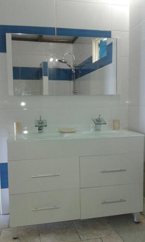 a white bathroom with a sink and a mirror at SLEMAN Franck in Les Anses-dʼArlets