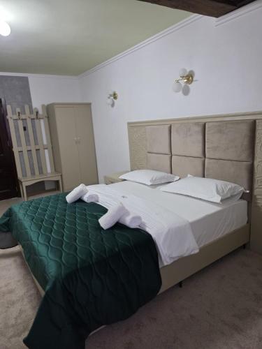 a bedroom with a large bed with white sheets and pillows at Pensiunea La Cetate in Târgu Neamț