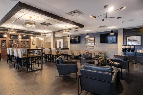 a restaurant with chairs and tables and a bar at Four Points by Sheraton Louisville Airport in Louisville