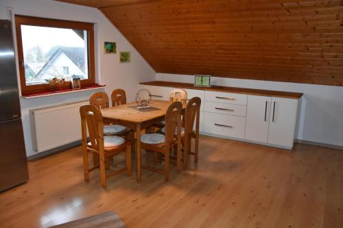 a kitchen with a table and chairs in a room at FeWo Wacholderheide in Langenau