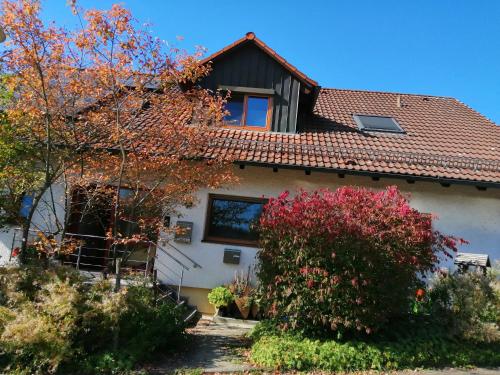 a white house with a red roof at FeWo Wacholderheide in Langenau