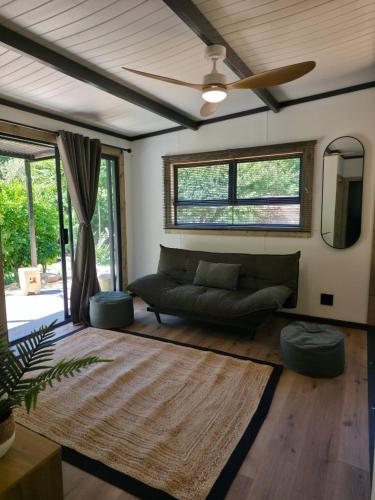 a living room with a couch and a ceiling fan at Luxury Unit with Mountain Views & Splash Pool in Oudtshoorn