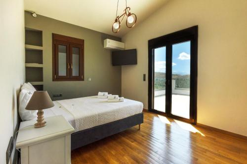 Un dormitorio con una cama y una ventana grande. en Villa Haria, en Káto Váthia