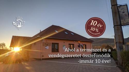 a building with a sign in front of it at Vár-Liget Vendégház in Kisnána