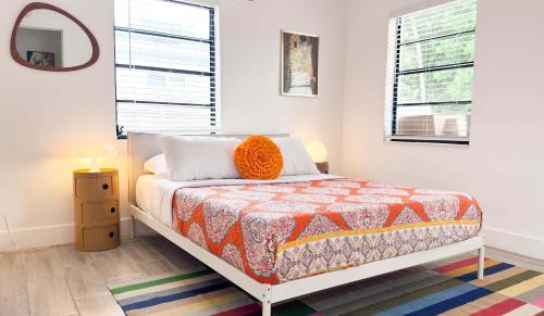 een slaapkamer met een bed met een oranje kussen erop bij Cloud Nine - Wilton Drive Jacuzzi Backyard in Fort Lauderdale