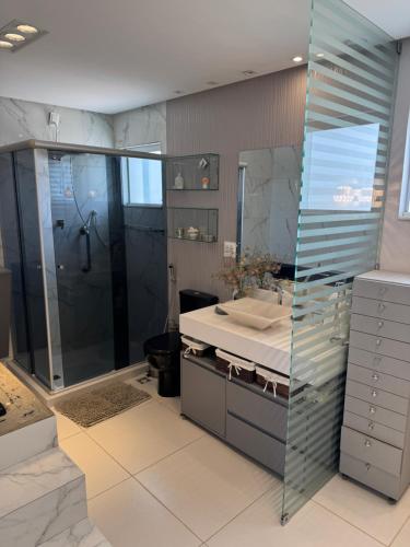 ペトロリーナにあるCasa agradável em Petrolina, alugue com Sevé!の洗面台、シャワー、鏡を備えたバスルーム