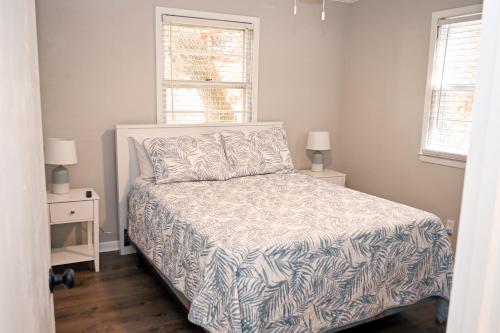 a bedroom with a bed and two night stands and a window at The Salty Lime in Emerald Isle