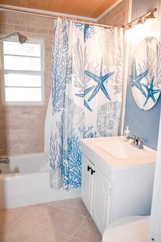 a bathroom with a blue and white shower curtain at The Salty Lime in Emerald Isle
