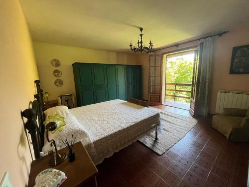 a bedroom with a bed and a window and a couch at Casa con giardino e vista sulle montagne in Cutigliano
