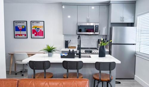 een keuken met een kookeiland met stoelen en een koelkast bij The Hideaway - Wilton Manors in Fort Lauderdale
