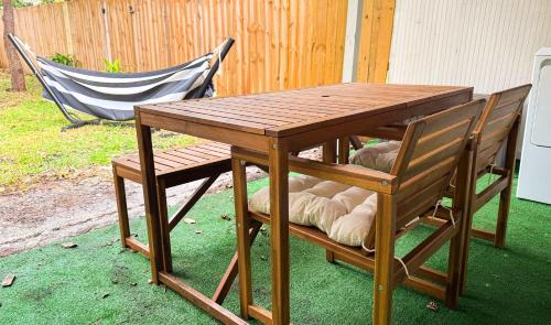 een houten tafel en twee stoelen met een tafel en een bank bij The Hideaway - Wilton Manors in Fort Lauderdale