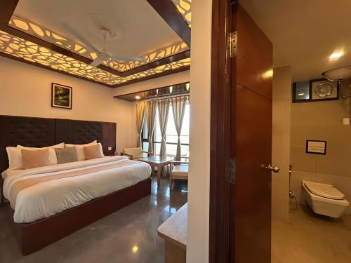 a bedroom with a large bed and a bathroom at Dwaper Palace A Luxury Property Near Library Chowk, Mussoorie in Mussoorie