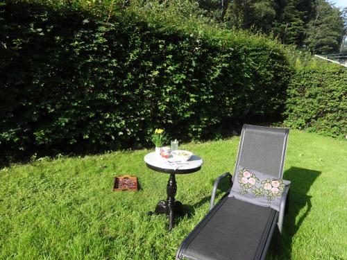 a small table and chair in the grass at Casa Mundo Bed & Breakfast in Vejle
