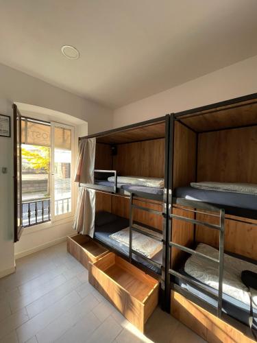 two bunk beds in a room with a window at Downtown River Hostel in Donostia-San Sebastián