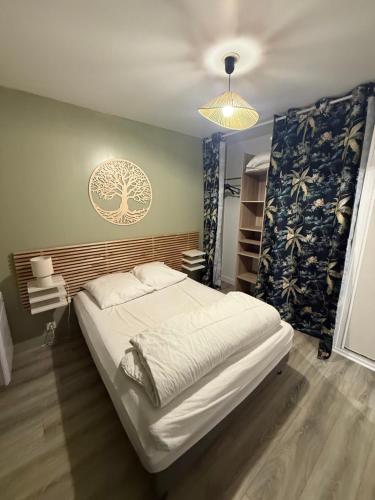 een slaapkamer met een groot bed en een kroonluchter bij 2 PIECES CENTRE ET MER in Cabourg