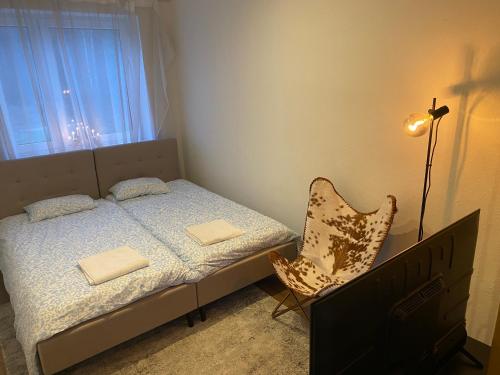 a small bedroom with a bed and a chair at Karula Stay - 1 Room City Apartment in Antsla