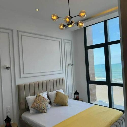 una camera da letto con un letto con vista sull'oceano di Le Paradis Du Figuier a Boumerdès