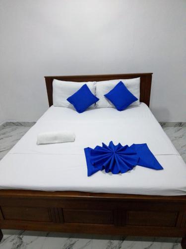 a bed with blue pillows and blue bows on it at Mwembeni Abode in Bamburi