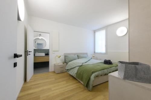 a white bedroom with a bed and a bathroom at Appartamento Santa Maria Nuova in Reggio Emilia