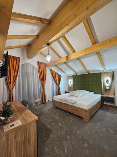 a bedroom with a large bed in a room with wooden ceilings at Wolf Chalet - Moieciu de Sus in Moieciu de Sus