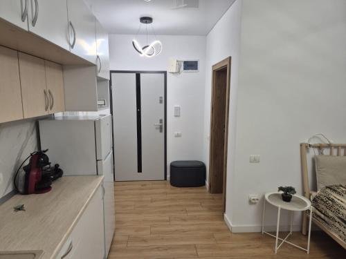 eine Küche mit einem Kühlschrank und einem Tisch im Zimmer in der Unterkunft Studio Valeria - Promenada Signature , Mamaia Nord in Năvodari