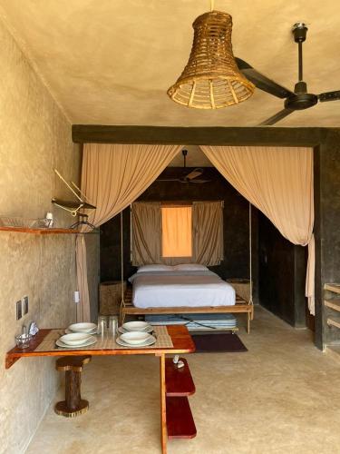a bedroom with a bed and a table with plates on it at Casa MANDALA in Santa María Colotepec