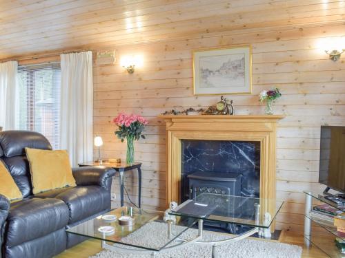 Una sala de estar con un sofá y una chimenea. en Lodge 5, en Bridgnorth