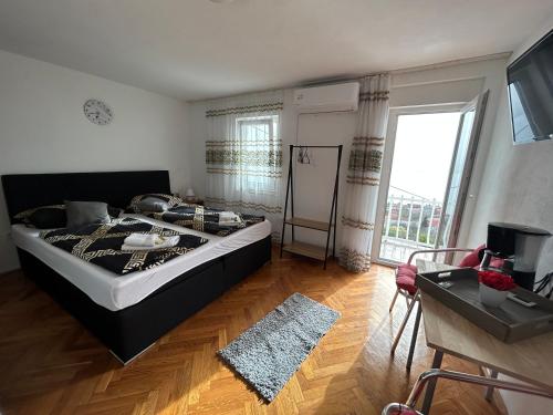 een slaapkamer met een groot bed en een groot raam bij Kuća za odmor Dramalj in Dramalj