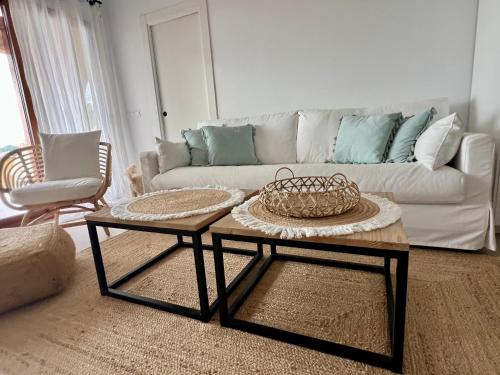 een woonkamer met een bank en twee tafels bij LUXURY PROPERTY ALTEA, BeachFront in Altea la Vieja
