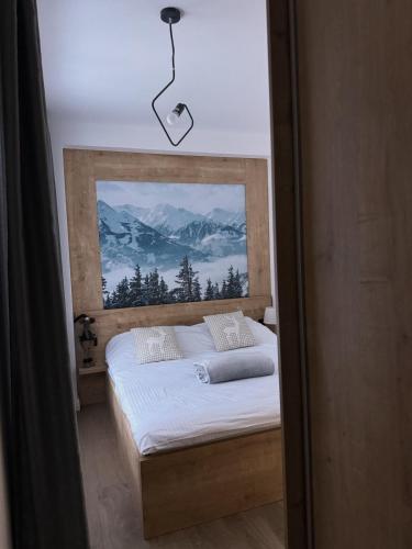 a bedroom with a bed with a view of mountains at Apartman ISKRA Villa Mont in Jahorina