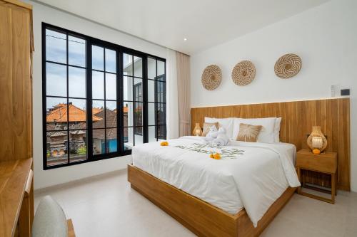 ein Schlafzimmer mit einem Bett, auf dem ein Teddybär liegt in der Unterkunft Bali Taoka Villa Tanah Lot in Tanah Lot