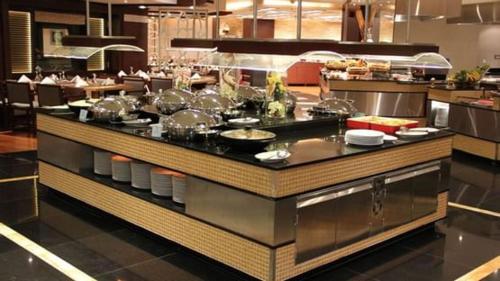 a restaurant kitchen with a counter with many dishes at فيلا خاصة في آي بي إطلالة على الحرم - و عنوانها أبراج مكة in Makkah