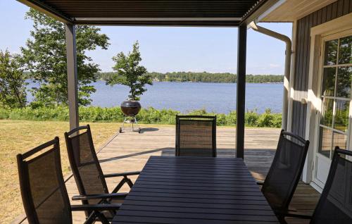 Beautiful Home In Bolmsö With Wifi في Bolmsö: شرفة مع طاولة وكراسي وشواية