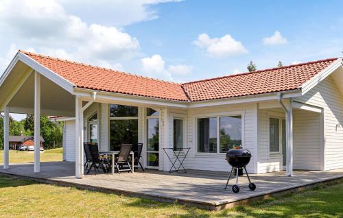 Beautiful Home In Bolmsö With Sauna في Bolmsö: منزل به شواية على سطح خشبي