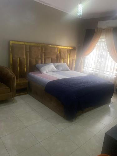 a bedroom with a large bed with a blue blanket at Flexy Short-let in Sagamu