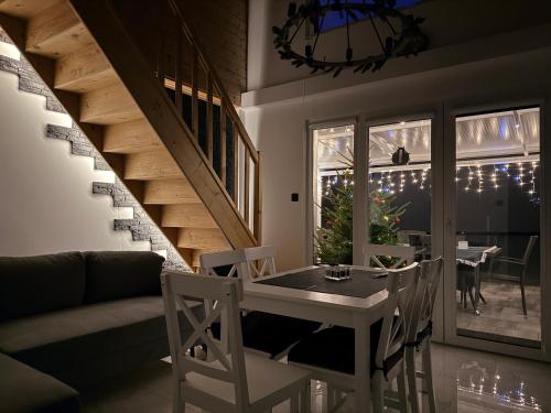 ein Wohnzimmer mit Tisch und Stühlen und einer Treppe in der Unterkunft Przedświt in Mukrz