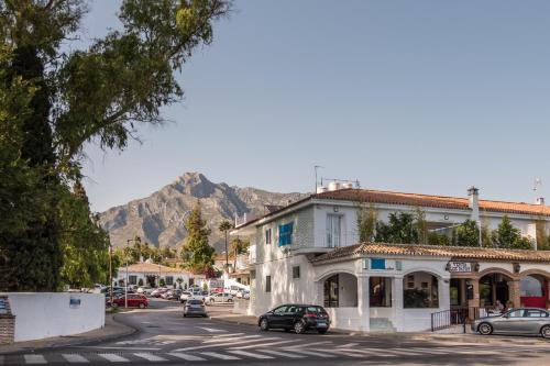 een straat in een stad met een berg op de achtergrond bij Bluebelle Marbella in Marbella