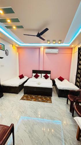 a room with two beds and a ceiling fan at devkritii innn stays in Faizābād